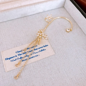 Detail einer vergoldeten Quasten-Ohrklemme mit Zirkonia-Schmetterling und Blumen
