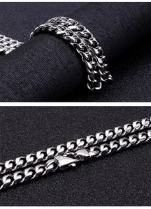 Macro detail of silver cuban link chain with lobster clasp on black background
