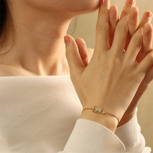 Detailed macro view of two gold elephants set with white cubic zirconia on a chain bracelet
