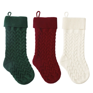 Three 46cm knitted Christmas stockings in green, red, and ivory with cable knit texture
