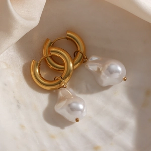Baroque pearl drop earrings in 18K gold plated stainless steel on a white shell tray