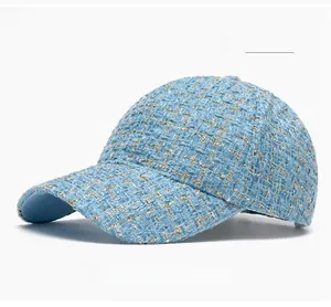 Détail macro du tissu tweed bleu ciel avec fils dorés sur une casquette de baseball chic