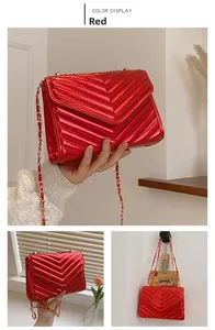 Detail of red patent faux leather crossbody bag with classic chevron quilted stitching