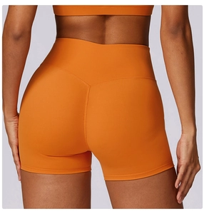 Close-up of bright orange high-waisted yoga shorts with V-shaped lifting back seam