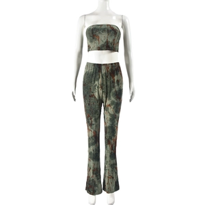 Dettaglio del tessuto tie-dye verde sul set con top a fascia e pantaloni a zampa