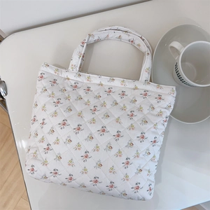 Detailed macro view of quilted floral cotton handbag with pastel flower patterns