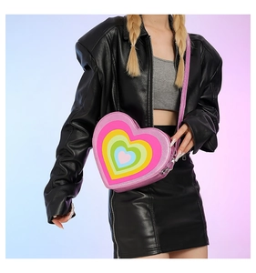 Detail of a heart-shaped crossbody bag with rainbow layered patterns and glitter strap