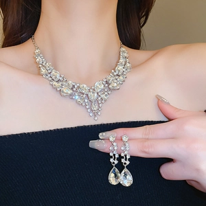 Dettaglio del set collana a fiore argento e orecchini a goccia indossati da modella