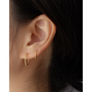 Elegant s925 silver gold-plated twisted hoop earrings shown on a model's ear