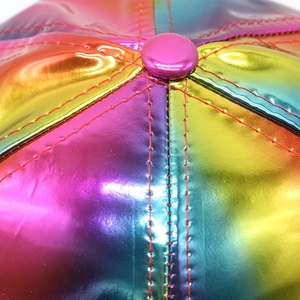 Macro detail of rainbow metallic patent leather baseball cap with red stitching