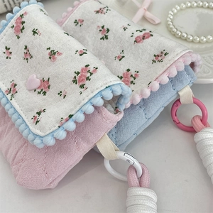 Detailed close-up of quilted floral cotton pouches for CCD cameras with plush ball lace