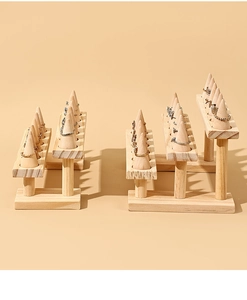 Macro shot of tiered wooden ring display stands with conical pillars on beige backdrop