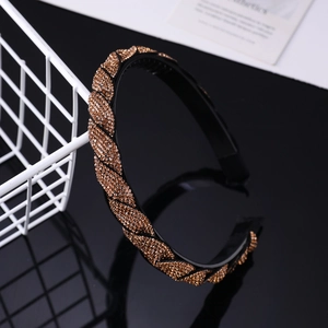Detail view of amber rhinestone braided headband with anti-slip teeth and glossy finish
