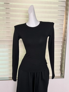 Détail montrant la texture côtelée et les épaulettes du t-shirt noir à manches longues
