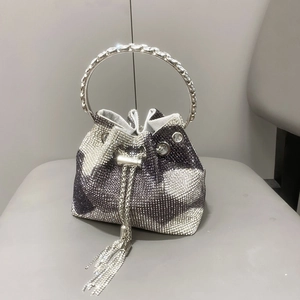 Dettaglio della borsa a secchiello con strass, motivo a pois e manico ad anello gioiello