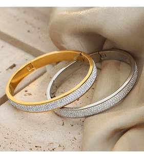 Detailed close-up of gold and silver plated bangles with sparkling white cubic zirconia stones