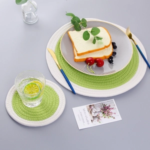 Two-piece set of green and white woven cotton table mats with spiral texture for dining decor