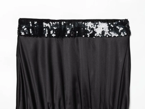 Detail shot of shimmering black sequins and silky satin fabric on a tube top