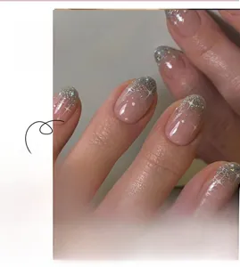 Detail of pink gradient press-on nails with silver glitter tips and white star patterns