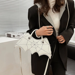 Detailed macro view of a white PU leather bat wing bag with black spider web embroidery