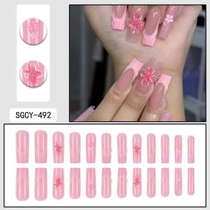 Pink gradient French press-on nails with 3D floral accents and 24-piece trapezoidal shape