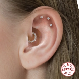 Close-up of S925 sterling silver earring set with zircons and floral motifs on ear