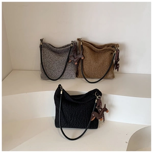 Detailed view of wool shoulder bags in grey, brown, and black with cute leather puppy charms