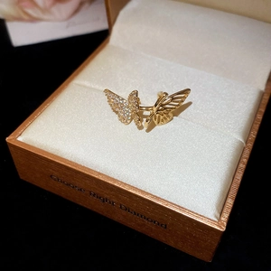 Macro detail of golden butterfly ear cuff featuring crystal paving and hollow design