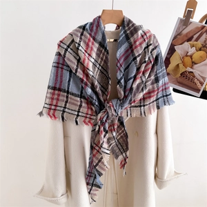 Classic plaid warm cashmere-feel scarf with tassels draped over a white coat