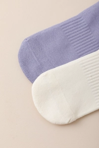 Close-up of knit cotton yoga socks in purple and beige showing detailed fabric texture