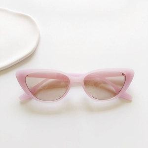 Detail of pink matte cat eye sunglasses with gradient lenses on a minimalist background
