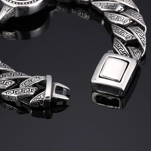 Macro shot of stainless steel bracelet featuring Greek Key pattern and secure clasp