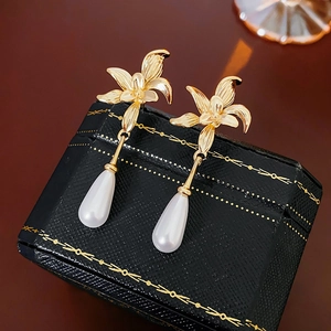 Detailansicht der 14K vergoldeten Blumenohrringe mit eleganten weißen Perlentropfen