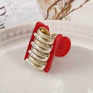 Chic red heart acrylic hair claw clip for women on a decorative ceramic plate