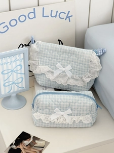 Detail of blue plaid quilted pouch set featuring delicate white lace and ribbon bow