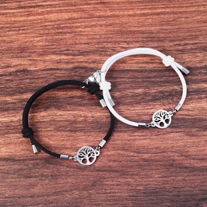 Detail of tree of life charm and magnetic heart pendants on adjustable cord bracelets