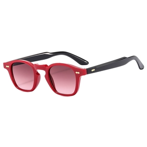 Occhiali da sole retrò rossi e neri con lenti sfumate rosa e accenti metallici dorati