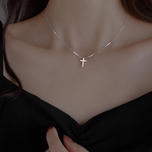 Minimalist silver cross necklace for women worn on the neck with a fine chain