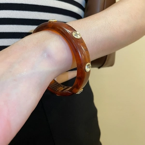 Detailed shot of amber tortoise resin bracelet with sparkling crystal inlay on wrist