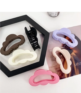 Flat lay of six matte cloud-shaped hair claw clips in assorted soft pastel colors