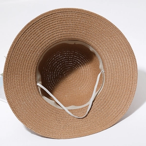 Internal view of brown straw hat featuring a beige sweatband and white elastic wind cord