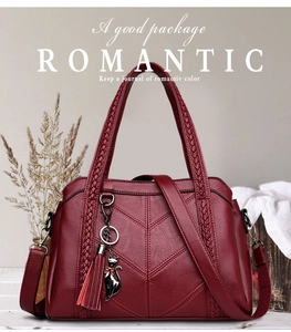Detail of burgundy textured leather tote with V-quilt pattern and cat charm