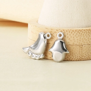 Macro shot of silver bird and Hamsa hand charms for DIY jewelry making accessories