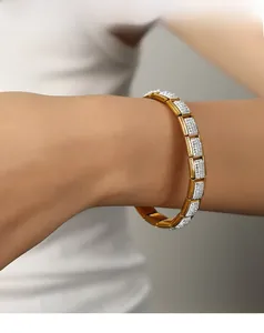 Dettaglio di un bracciale in acciaio inossidabile dorato con pavé di zirconi al polso