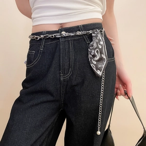 Detailed shot of vintage metal belt chain with black and white floral silk scarf and pearl charm