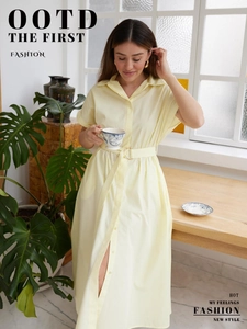 Detail of yellow cotton midi shirt dress featuring button-down front and waist belt