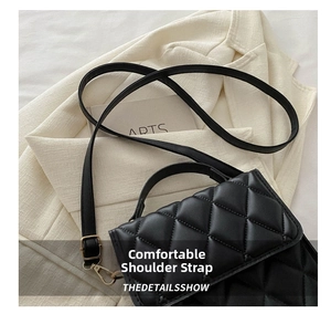 Détail de la texture en cuir matelassé et de la bandoulière réglable sur le sac noir