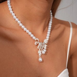 Macro view of crystal encrusted leaf pendant on elegant white pearl beaded necklace