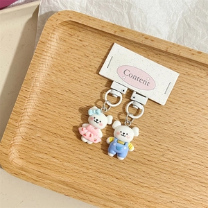 Dettaglio di portachiavi orsetto cartone animato in rosa e blu su carta regalo
