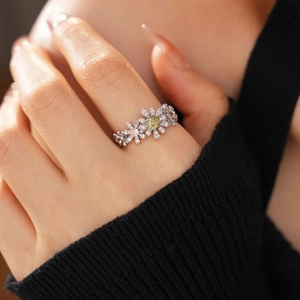 Macro shot of silver daisy flower ring with zircon inlays and pale yellow center stone